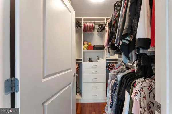 a view of walk in closet with clothes and shoes