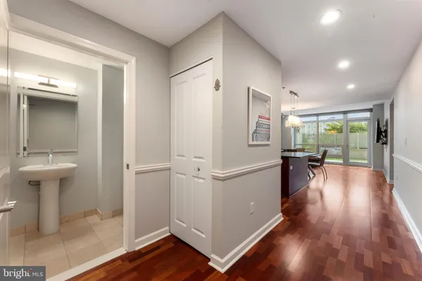 a view of a hallway view with wooden floor and a living room