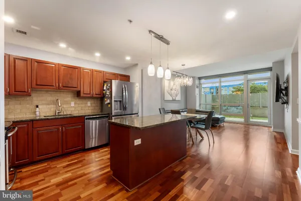 a kitchen with stainless steel appliances granite countertop sink stove top oven and cabinets