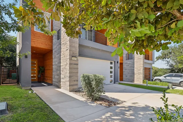 a view of a house with a tree and a yard