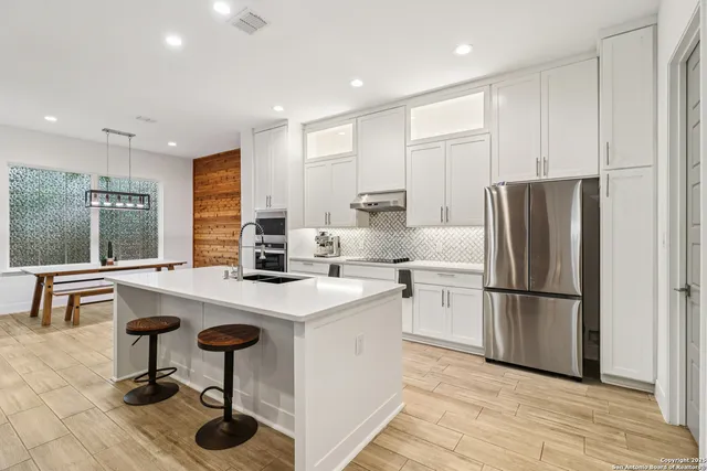 a kitchen with stainless steel appliances a sink stove and cabinets