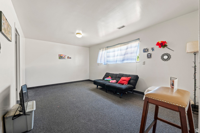 2402 710 North Provo, UT 84601 - Photo 5 of 15 Spacious room featuring neutral white walls, a single window with blinds, and dark gray carpeting