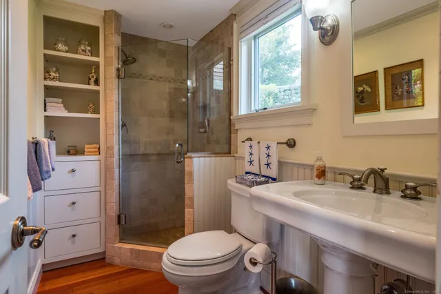 a bathroom with a sink a toilet and shower