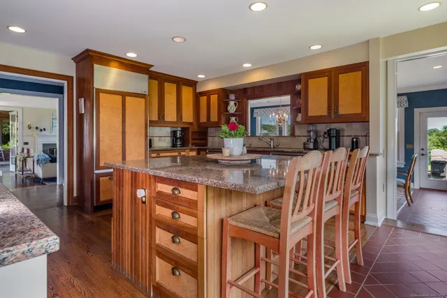 a kitchen with stainless steel appliances granite countertop dining table chairs cabinets and wooden floor