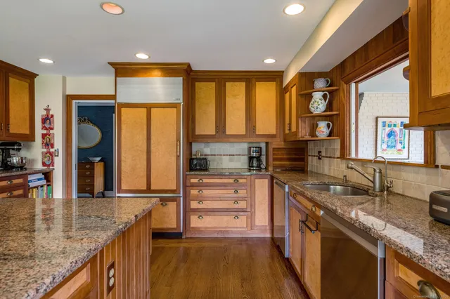 a kitchen with stainless steel appliances granite countertop a stove a sink and a refrigerator
