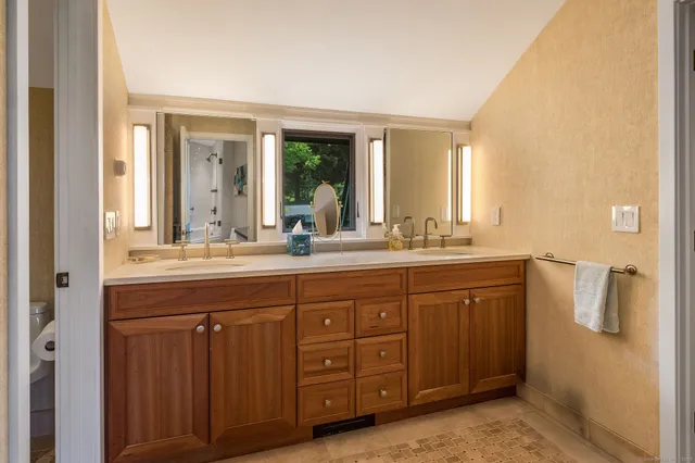 a bathroom with a granite countertop sink and a mirror