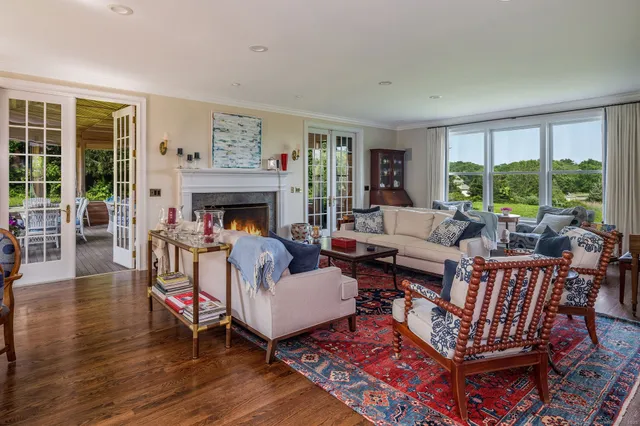 a living room with furniture fireplace and a large window