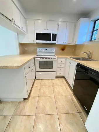 a kitchen with cabinets and appliances