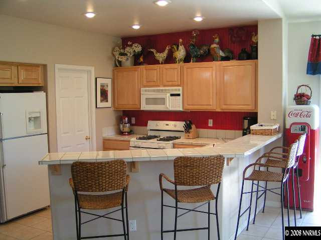 899 Caughlin Glen Reno, NV 89519 - Photo 2 of 9 a kitchen with a dining table chairs and refrigerator