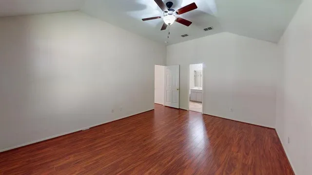 a view of an empty room with wooden floor