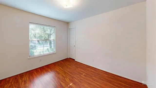 a view of an empty room with window and cabinet
