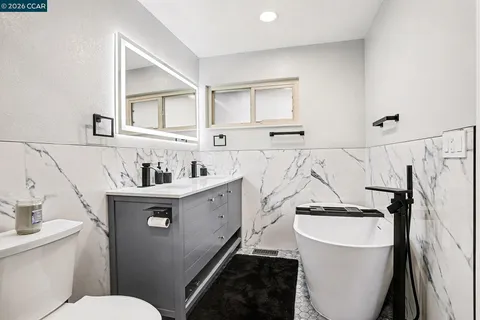 a bathroom with a sink a toilet and a mirror