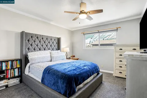 a bedroom with a large bed a chandelier and a book shelf