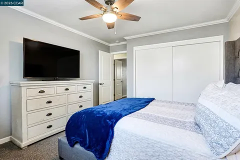 a bedroom with a bed a flat screen tv and a dresser