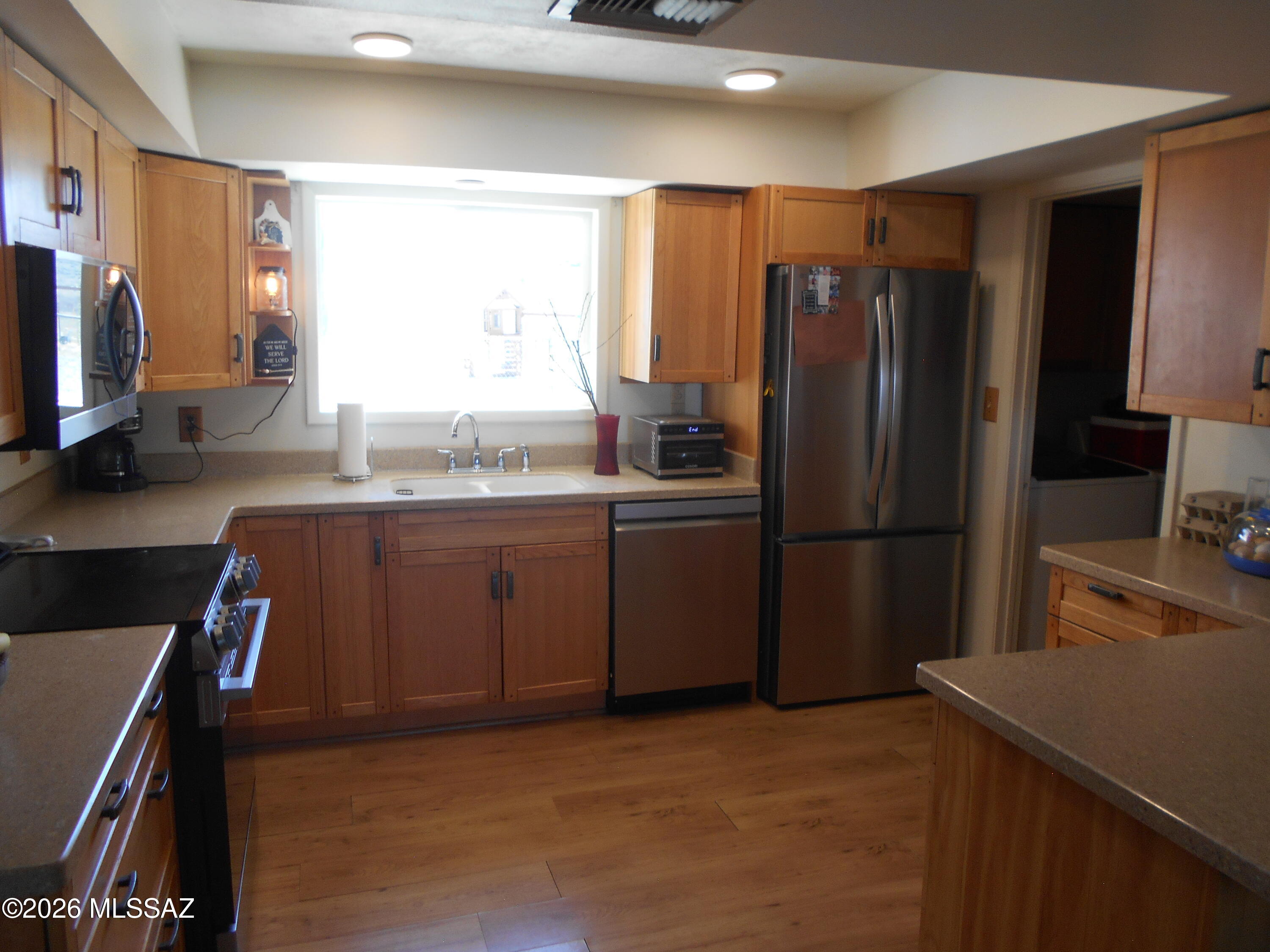 1201 East Old Stewart Road Willcox, AZ 85643 - Photo 4 of 49 a kitchen with stainless steel appliances granite countertop a refrigerator a stove a sink a washer dryer and white cabinets