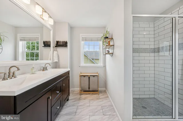 a bathroom with a double vanity sink a mirror and a shower
