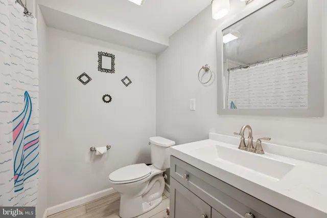 a bathroom with a sink a toilet and a mirror