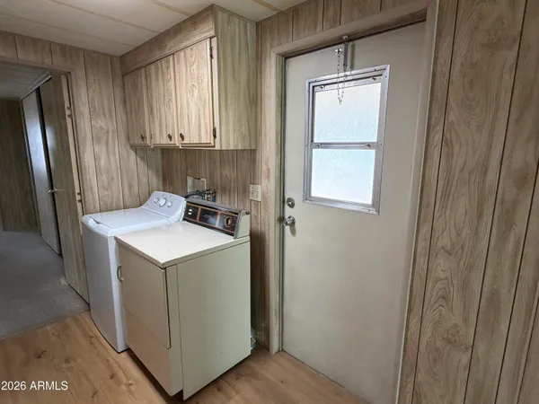 a utility room with wooden floor washer and dryer