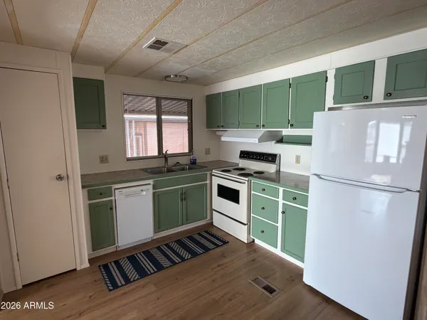 a kitchen with a refrigerator and a stove top oven