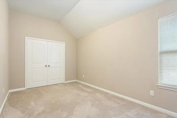 an empty room with windows and closet