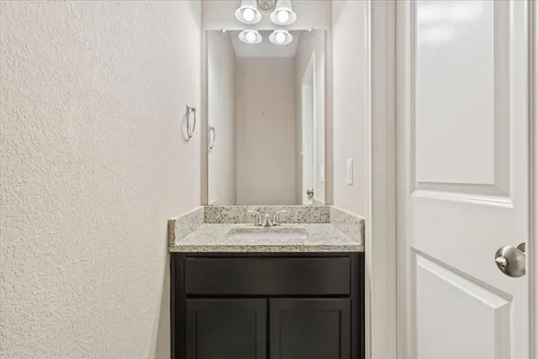 a bathroom with a sink vanity and a mirror