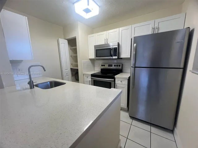 a kitchen with stainless steel appliances a refrigerator and a sink