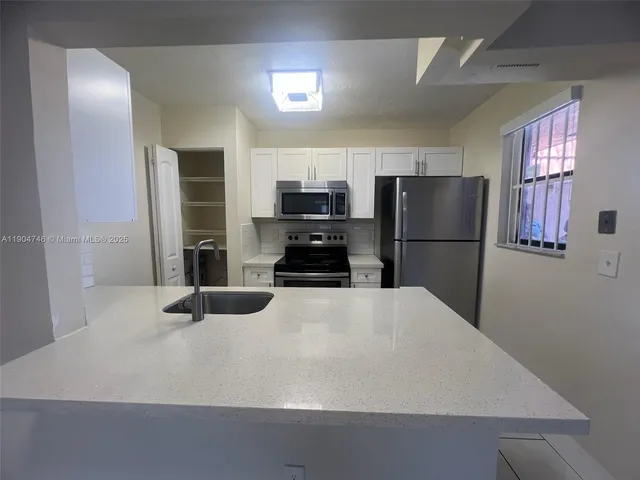 a kitchen with a refrigerator and a stove top oven