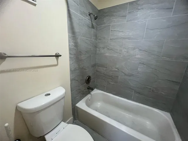 a white toilet sitting next to a bath tub