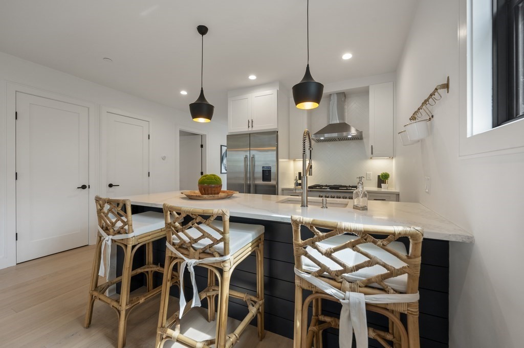 228 Webster Street, Unit 2 Boston, MA 02128 - Photo 12 of 32 a kitchen with a table chairs stove and white cabinets