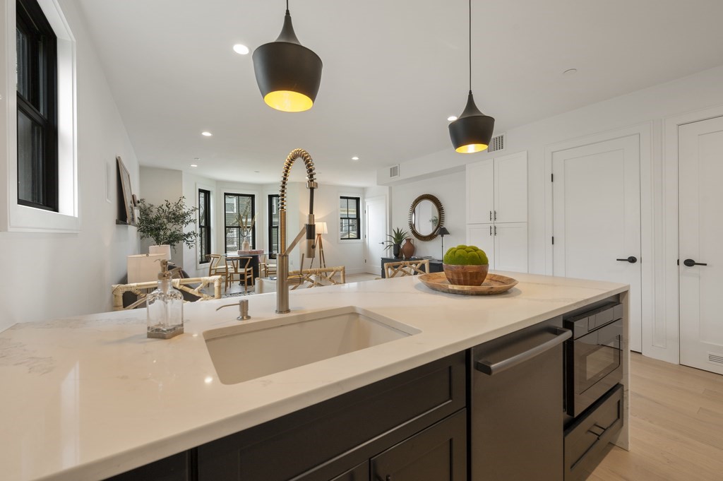 228 Webster Street, Unit 2 Boston, MA 02128 - Photo 14 of 32 a kitchen with a sink a chandelier and living room view