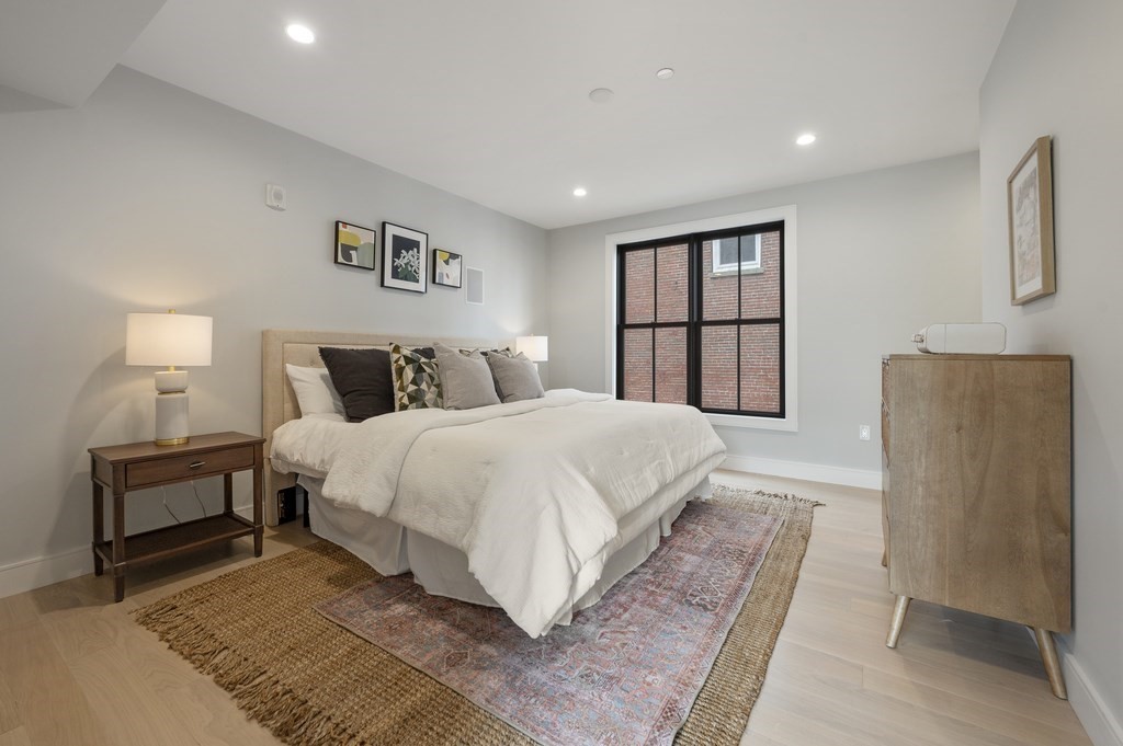 228 Webster Street, Unit 2 Boston, MA 02128 - Photo 18 of 32 a bedroom with a large bed and a lamp on table