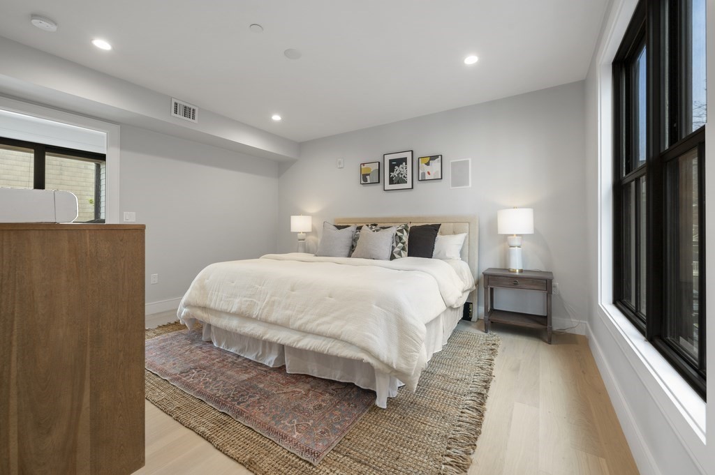 228 Webster Street, Unit 2 Boston, MA 02128 - Photo 19 of 32 a bedroom with a large bed and a chandelier