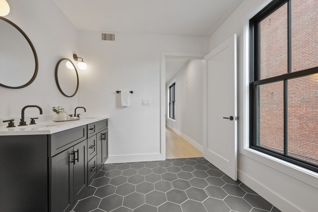 228 Webster Street, Unit 2 Boston, MA 02128 - Photo 21 of 32 a bathroom with a double vanity sink mirror and next to a window