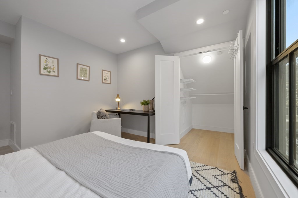 228 Webster Street, Unit 2 Boston, MA 02128 - Photo 23 of 32 a bedroom with a bed and a flat tv screen on a dresser