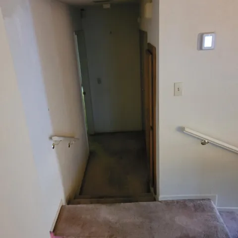 a view of empty room with wooden floor and fireplace
