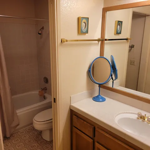 a bathroom with a granite countertop sink toilet and shower