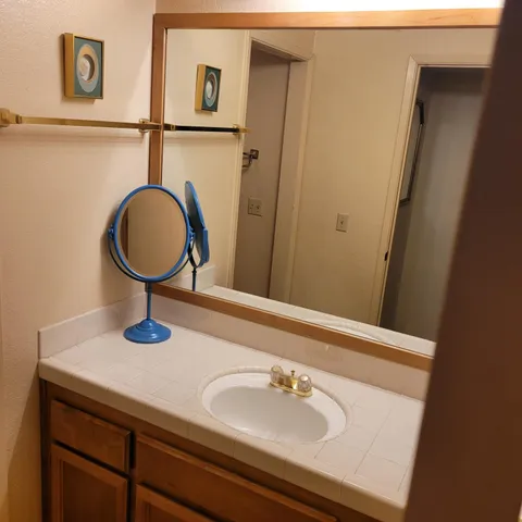 a view of an empty room with closet and wooden shelves