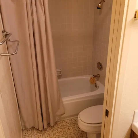 a view of an empty room with a cabinet and a window