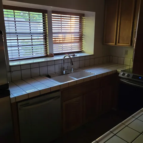 a kitchen with a sink a window and cabinets
