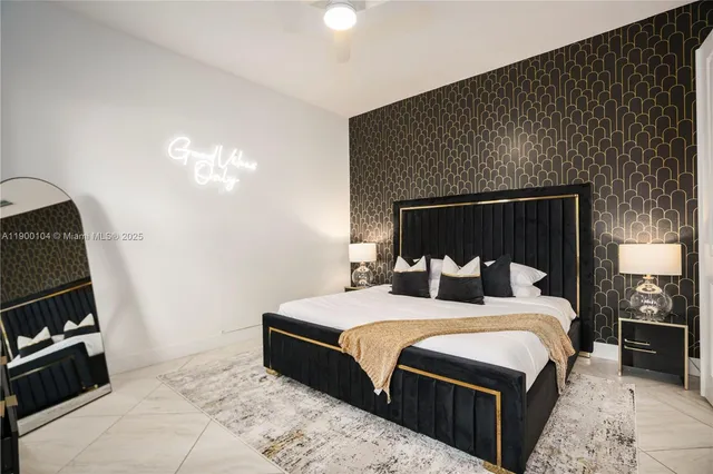 a bedroom with a bed and a flat tv screen on dresser