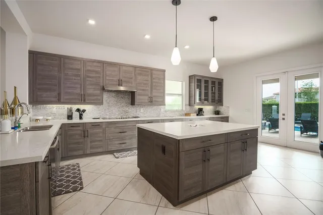 a kitchen with granite countertop white cabinets and stainless steel appliances