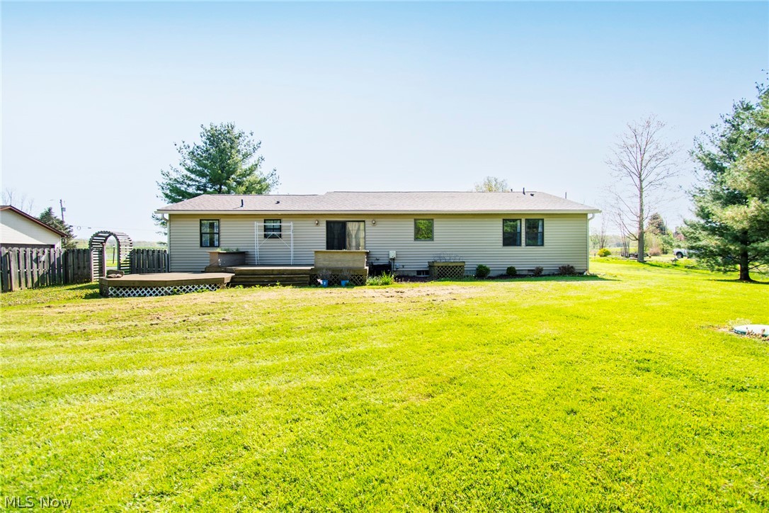 5561 Phillips Rice Road Cortland, OH 44410 - Photo 25 of 38 Rear view of house with a wooden deck and a lawn