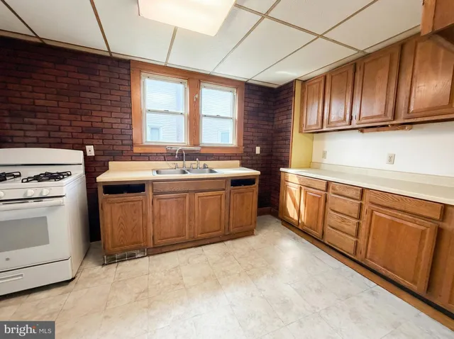 a kitchen with stainless steel appliances granite countertop a stove a sink dishwasher and cabinets with wooden floor