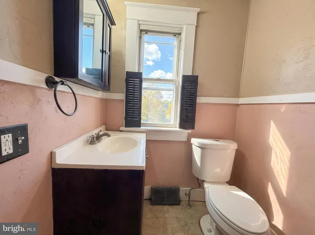 a bathroom with a toilet sink and mirror