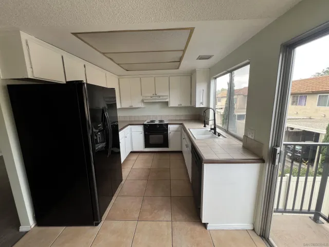 a kitchen with granite countertop a refrigerator and a sink