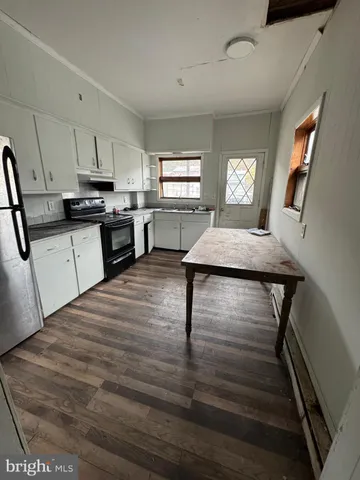 a kitchen with kitchen island white cabinets appliances and window