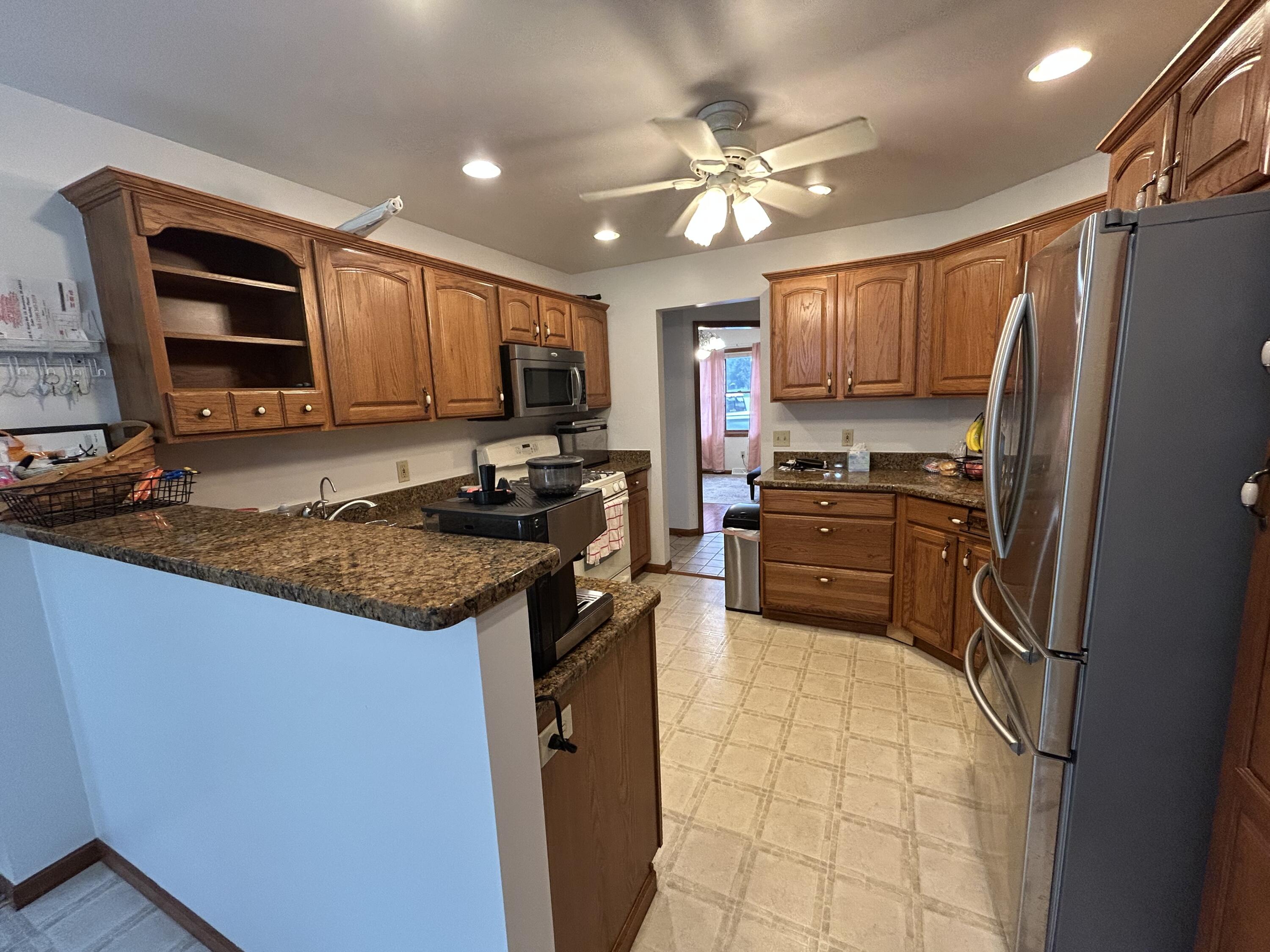 8876 North Lilac Street Demotte, IN 46310 - Photo 10 of 23 a kitchen with stainless steel appliances granite countertop a stove refrigerator sink and microwave