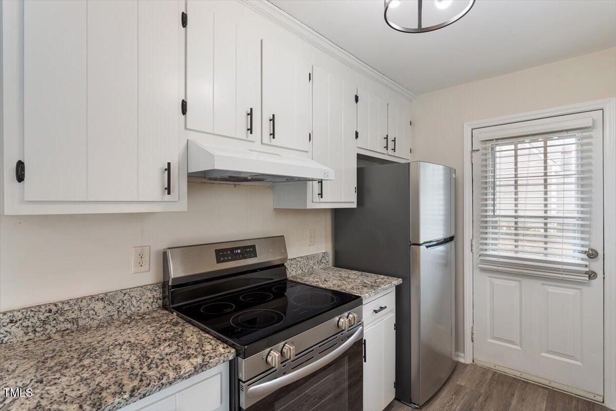 5144 Shield Circle Raleigh, NC 27603 - Photo 16 of 41 a kitchen with appliances a refrigerator and a stove top oven