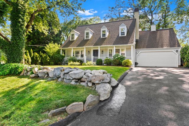 a view of a house with a big yard plants and large trees