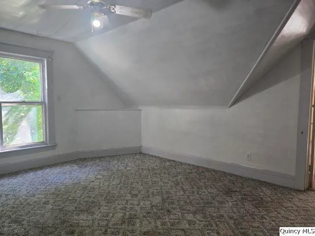 an empty room with chandelier fan
